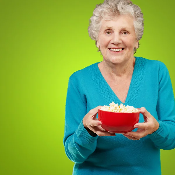 Старша жінка тримає попкорн — стокове фото