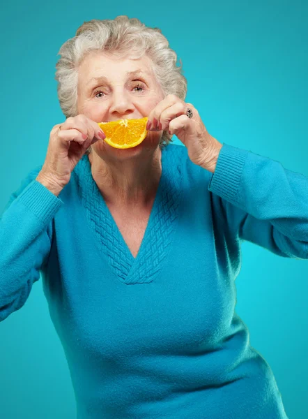 Mujer madura con una rebanada de fruta —  Fotos de Stock