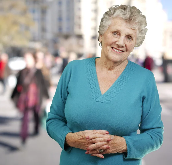 Портрет пожилой женщины, стоящей в переполненном месте — стоковое фото