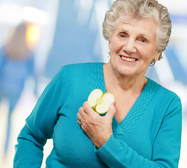 Porträtt av glad mogen kvinna medan du håller apple — Stockfoto