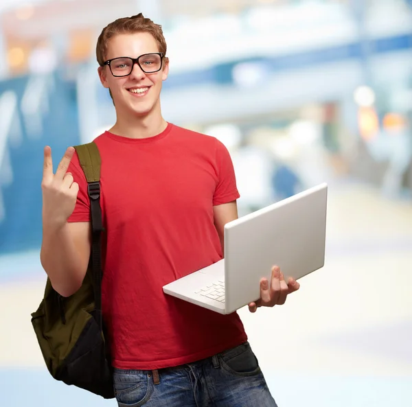 Man holding laptop and backpack — Stock Photo, Image