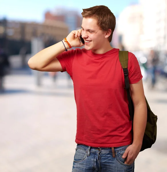 Portrait of young man talking on mobile at street — Stock Photo, Image