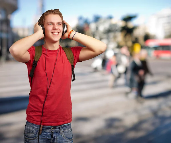 stock image Portrait of cheerful young student listening music with headphon