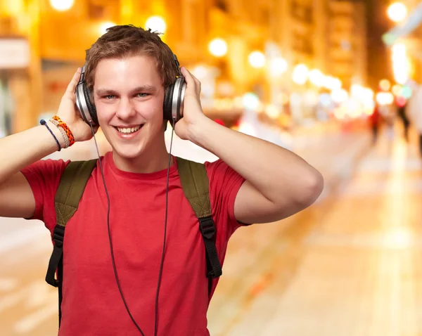 Portrait de jeune étudiant joyeux écoutant de la musique avec casque — Photo