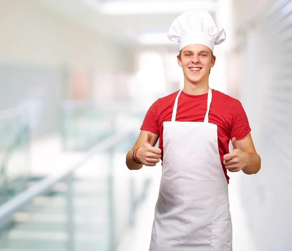 Retrato del joven cocinero haciendo símbolo de éxito en la entrada de m — Foto de Stock
