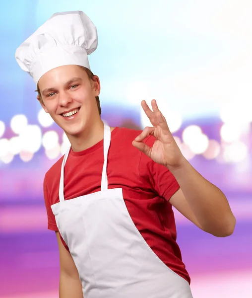 Soyut arka başarı sembolü yapan genç aşçı erkek portresi — Stok fotoğraf