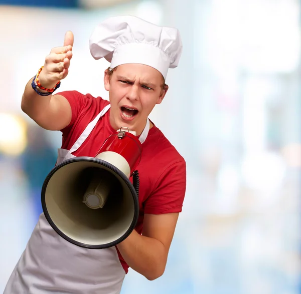 Retrato del joven cocinero gritando con megáfono y gesturín —  Fotos de Stock