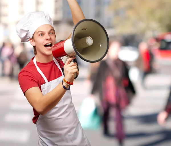 Portré, fiatal szakács férfi kiabált a megafon, a zsúfolt st — Stock Fotó