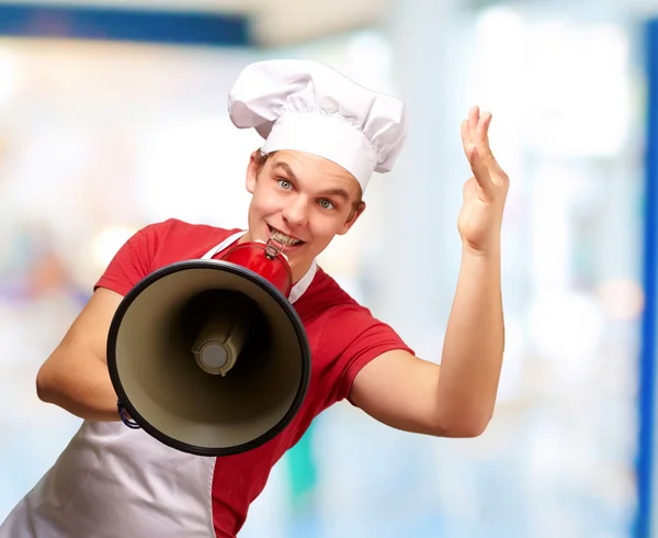 Porträtt av glad kock man skrika med MegaFon inomhus — Stockfoto