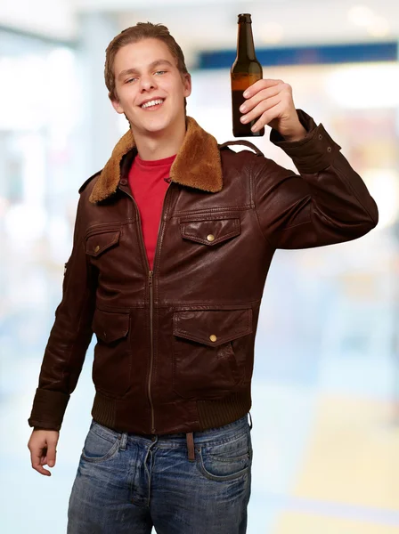 Portrét mladého muže drží pivo vnitřní — Stock fotografie