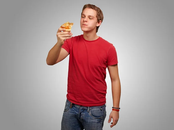 Portret van een jonge man eten van pizza — Stockfoto