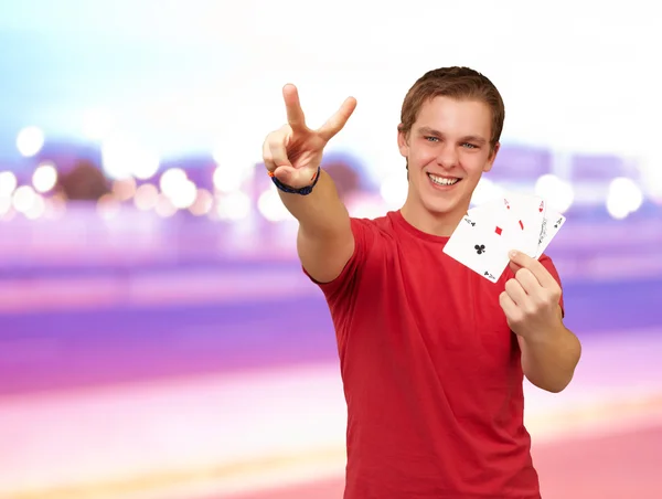 Porträtt av ung man gör en seger gest spela poker Mo — Stockfoto
