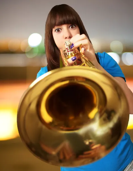 Portrait of a young girl blowing trumpet — Stock Photo, Image