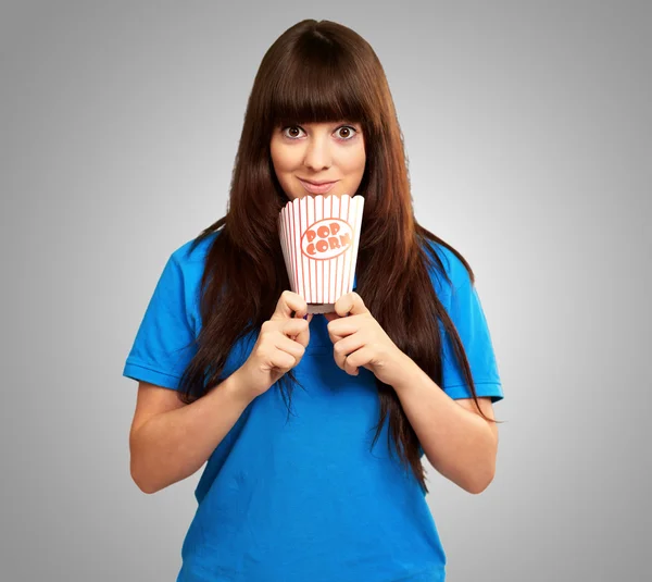 Portrait of a girl holding empty popcorn packet — Stock Photo, Image