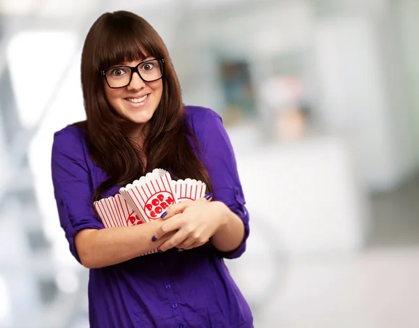 Ritratto di giovane donna che tiene il contenitore del popcorn — Foto Stock