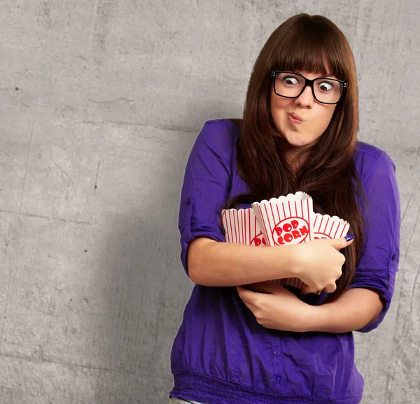 Porträtt av ung kvinna med popcorn behållare — Stockfoto