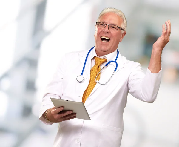 Doctor sosteniendo una tableta y feliz —  Fotos de Stock