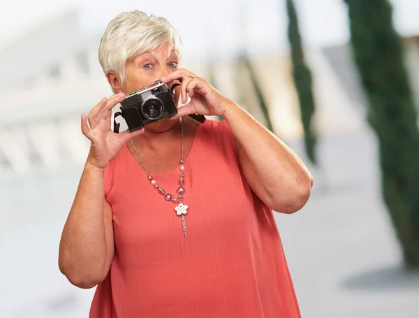 Senior mulher segurando câmera — Fotografia de Stock