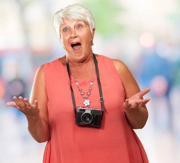 Starší žena nosí fotoaparát rameny — Stock fotografie
