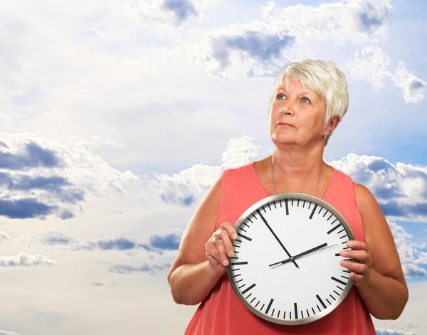 Старша жінка тримає годинник — стокове фото