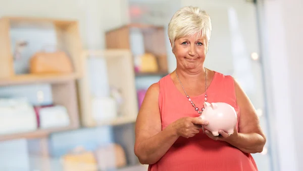 Vrouw zetten munt in Piggy Bank — Stockfoto