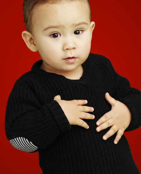 Πορτρέτο του αξιολάτρευτο παιδί που αγγίζουν το στομάχι κατά ένα κόκκινο πίσω — Φωτογραφία Αρχείου