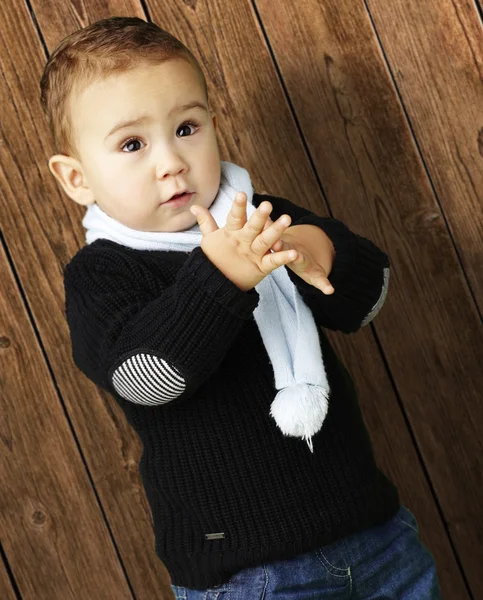Portrait of adorable kid clapping against a wooden wall — Stock Photo, Image
