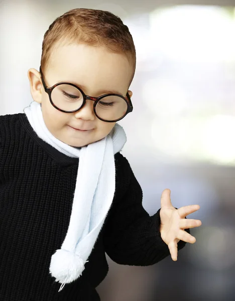 Portrait of kid wearing glasses looking down indoor — Stock Photo, Image