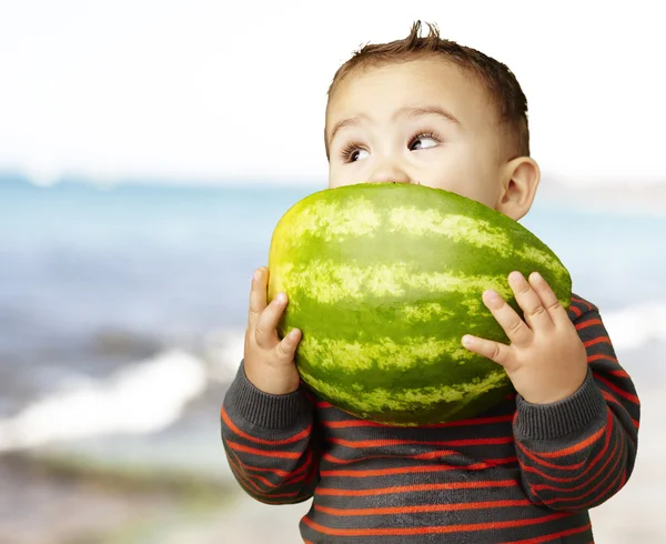 Porträt eines hübschen Kindes, das Wassermelone in der Hand hält und in der Nähe lutscht — Stockfoto