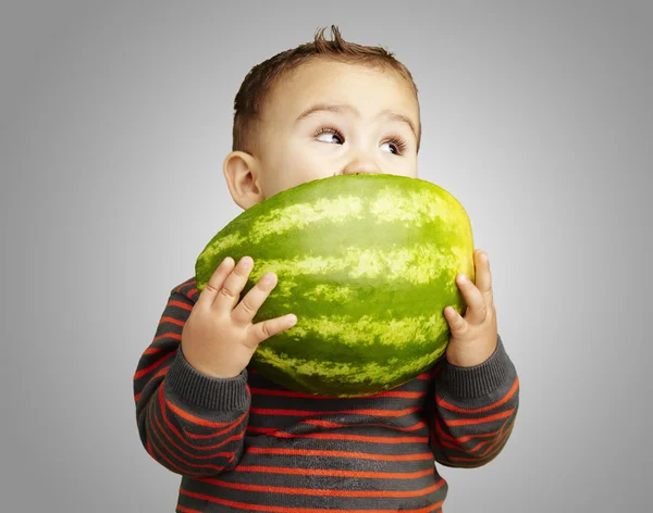 Portret van een knappe jongen holding watermeloen en zuigen agains — Stockfoto