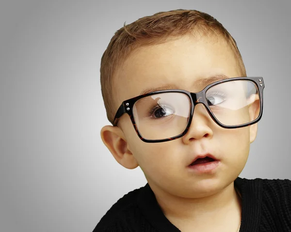 Retrato de criança usando óculos sobre fundo cinza — Fotografia de Stock