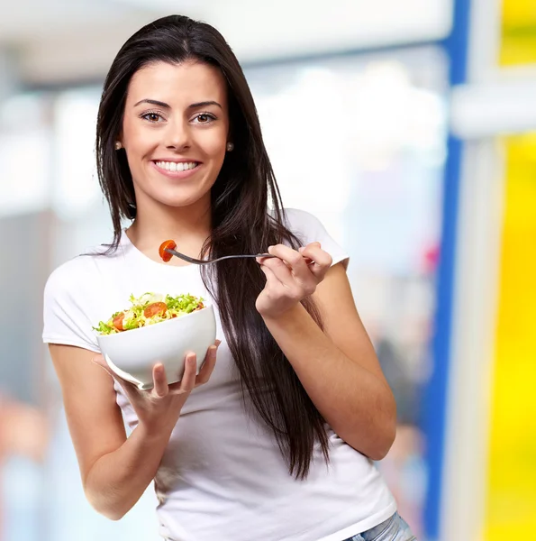 Porträtt av frisk kvinna äta sallad inomhus — Stockfoto