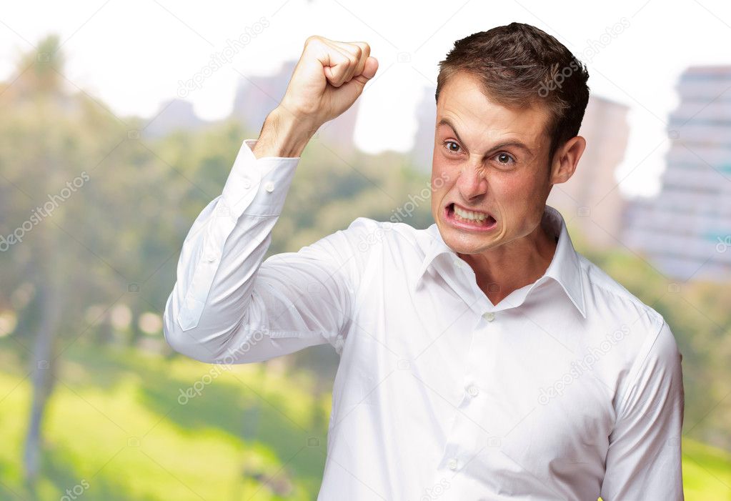 Portrait Of Angry Young Man Clenching His Fist