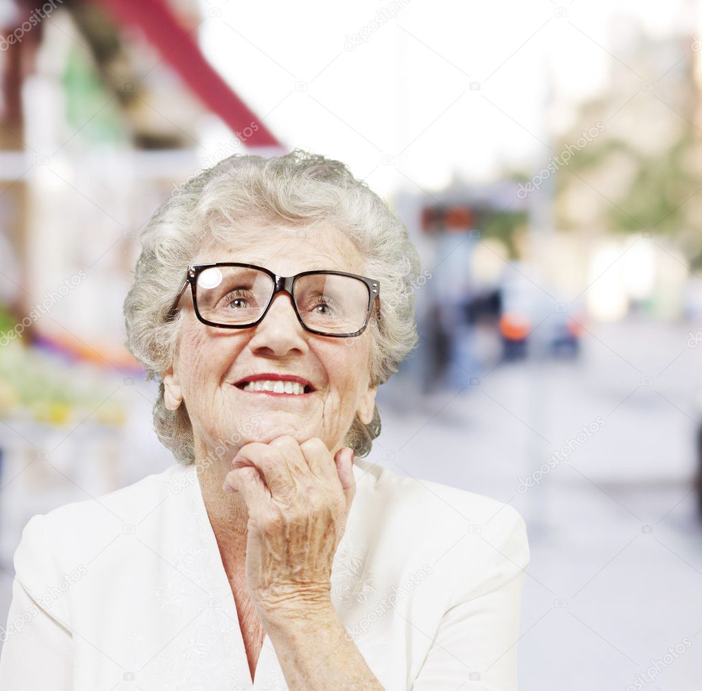 Portrait of senior woman thinking and looking up at street