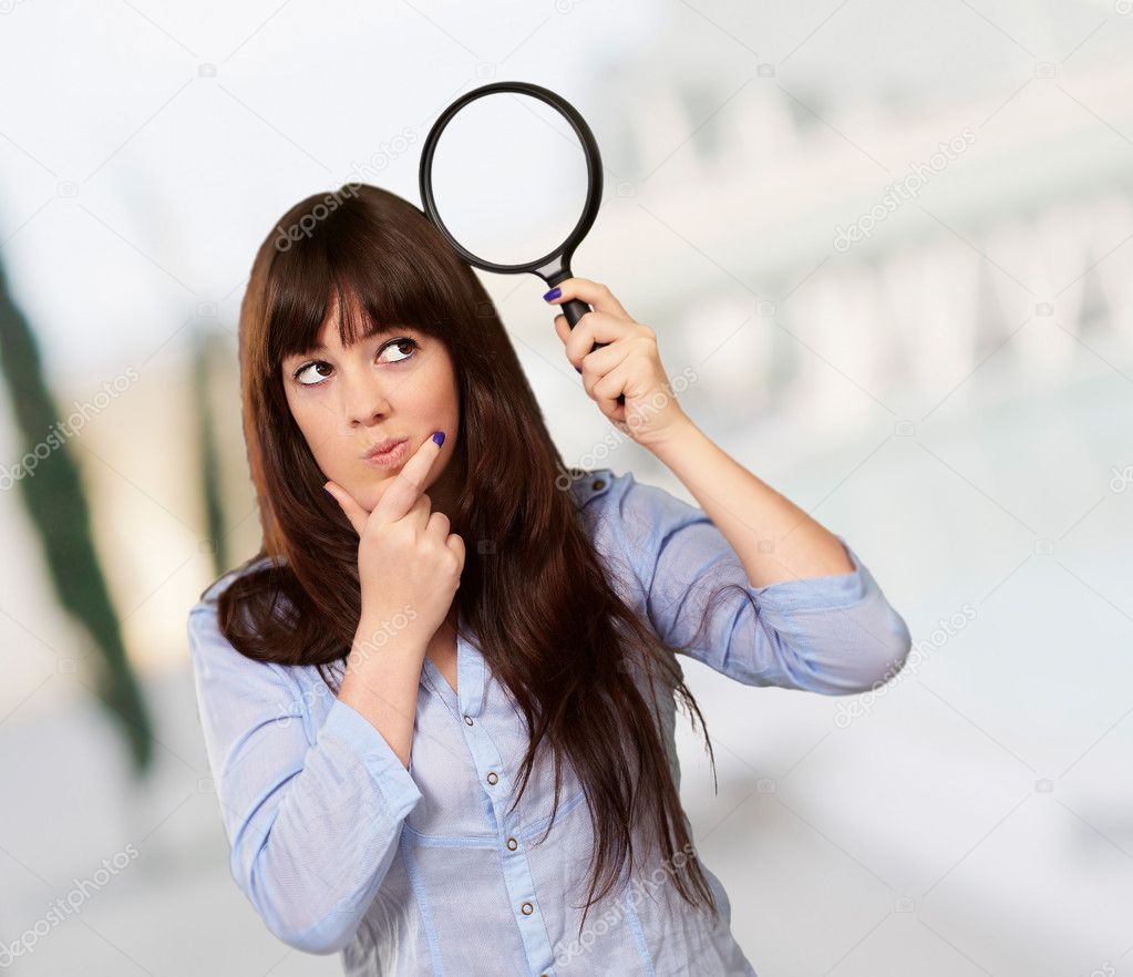 Portrait Of A Girl Holding A Magnifying Glass And Thinking