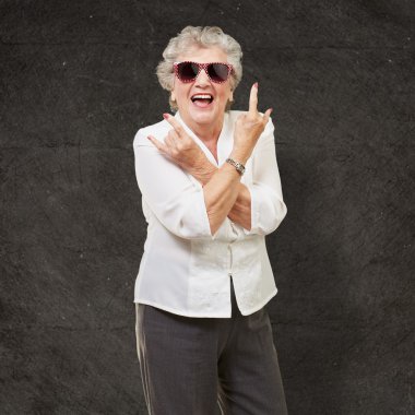 Senior woman wearing sunglasses doing funky action clipart