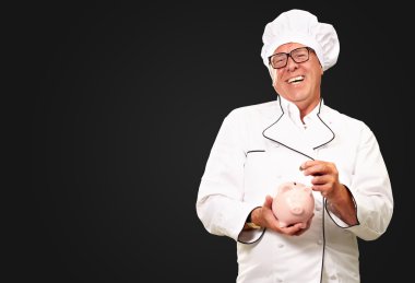 Chef Putting Coin In Piggybank clipart