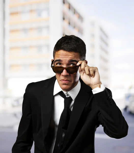 Portrait d'un homme d'affaires enlevant ses lunettes de soleil en ville — Photo