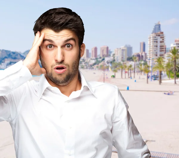 Portrait of young man surprised against a beach — Stock Photo, Image