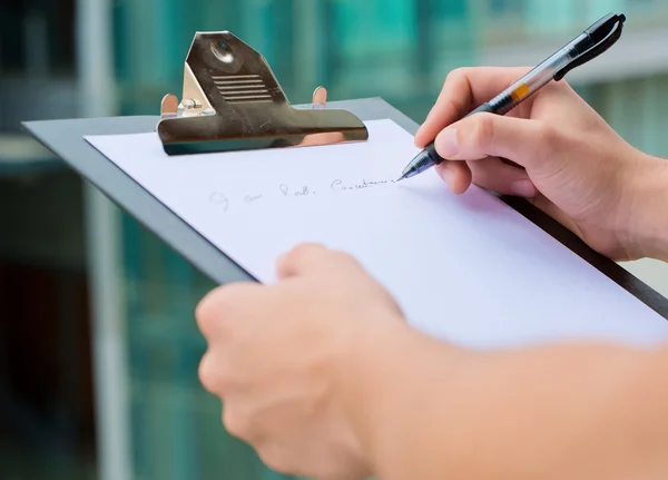 Businessman Holding A Clipboard And Writing — Stock Photo, Image