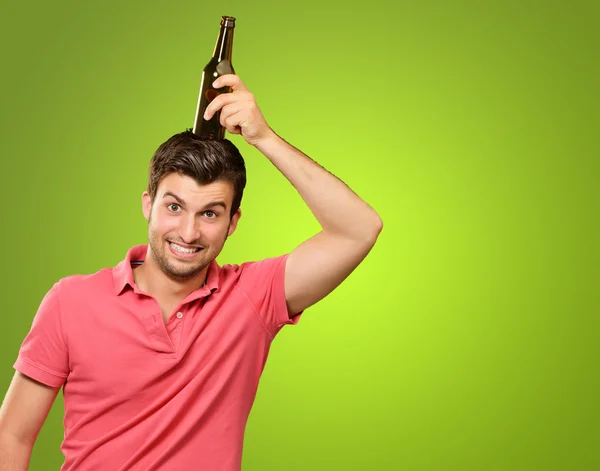 Podobizna mladého muže drží láhev na hlavu — Stock fotografie