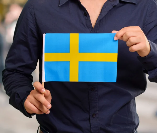 Man anläggning Svenska flaggan — Stockfoto