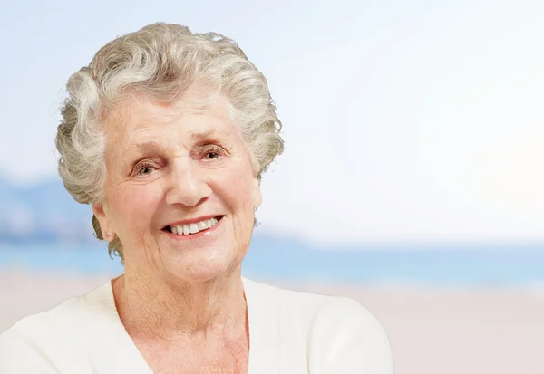 Gesunde Seniorin lächelt am Strand — Stockfoto