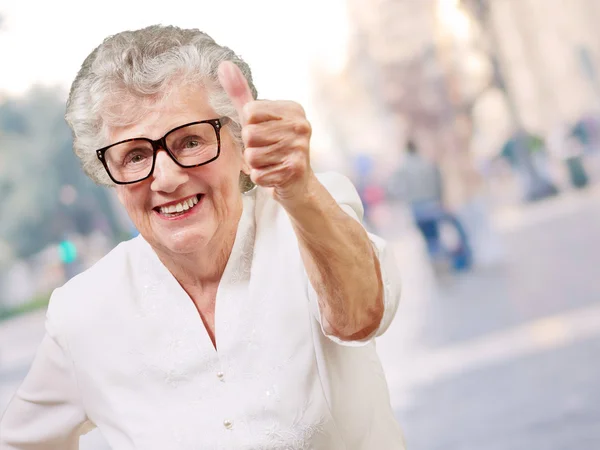 Ritratto di adorabile donna anziana che fa un buon gesto in città — Foto Stock