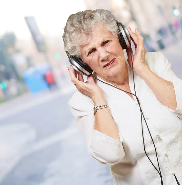 Portret kobiety starszy słuchanie muzyki w mieście — Zdjęcie stockowe