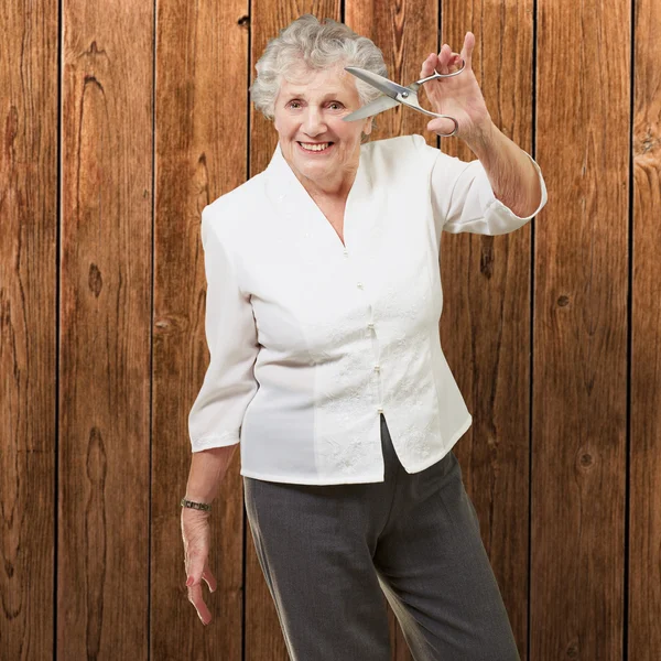 Mujer mayor sosteniendo tijeras —  Fotos de Stock