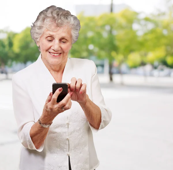 Mujer mayor usando el teléfono celular —  Fotos de Stock