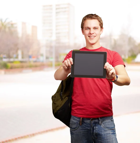 Porträtt av ung student man visar en digital tablet på city — Stockfoto