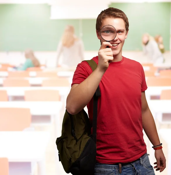 Retrato de um estudante olhando através de lupa — Fotografia de Stock