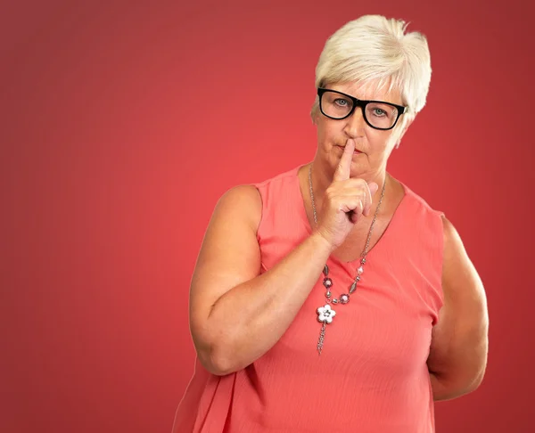 Femme âgée avec doigt sur les lèvres — Photo